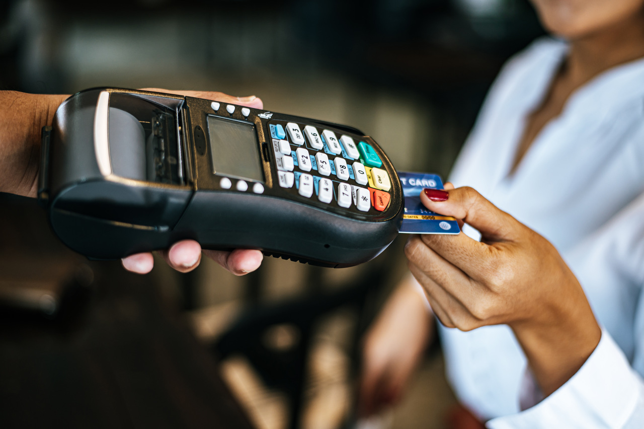 A card tapped on a payment terminal at a shop counter